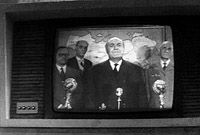 Le président s'addresse à la nation sur l'écran géant du bunker.